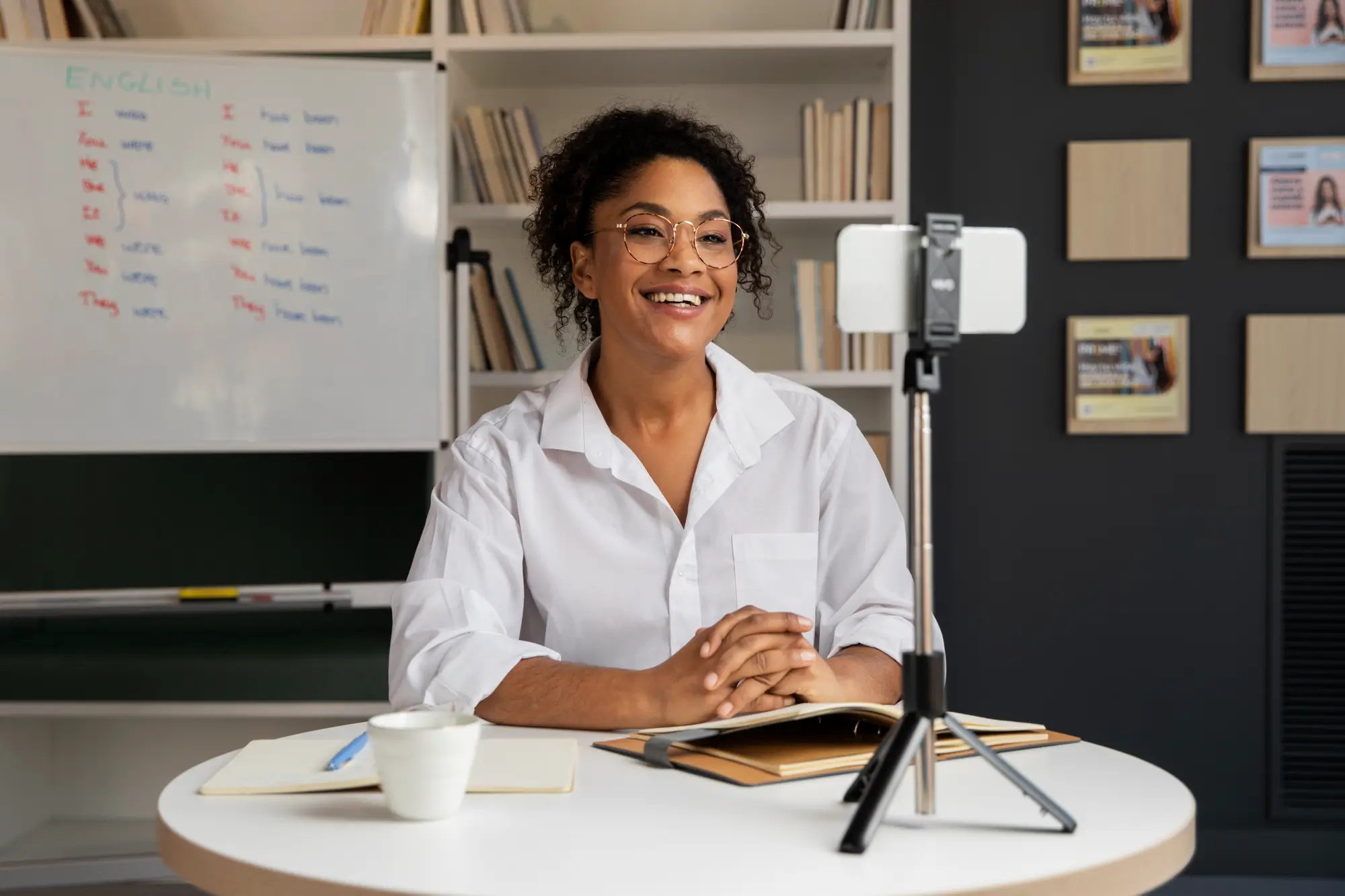 Student sat at desk looking smiling into video camera during online class