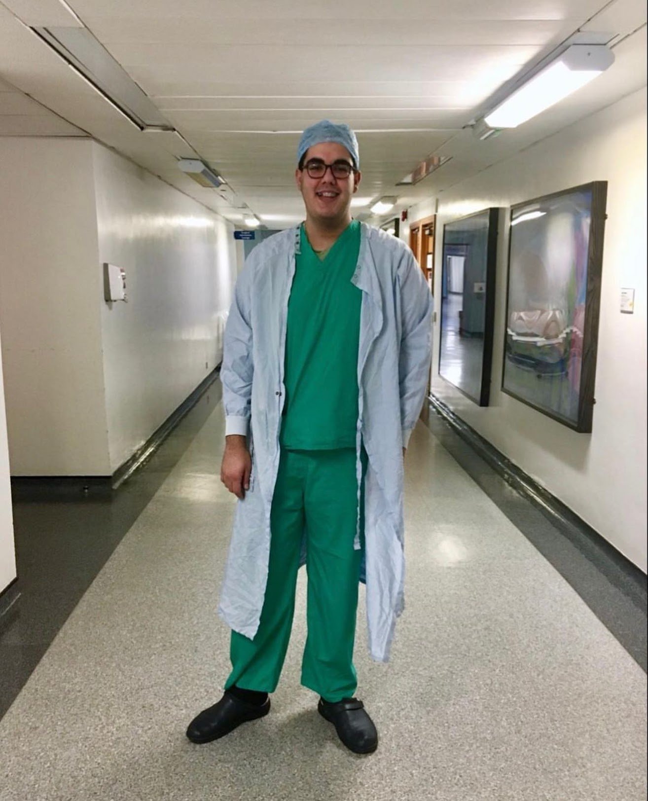 Dr Ahmad Almohtadi, dressed in scrubs with a surgical hat and gown.